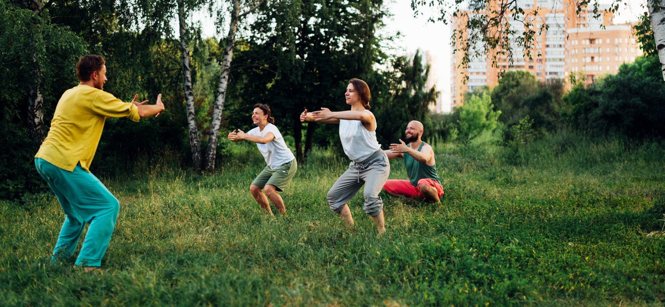 Trainer Teaches to Do Squat Exercise. Outdoor Qigong Practice.